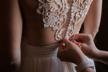 Hands Wearing of wedding dress. Elegant Lace and buttons. Beautiful Wedding Dress Design. 