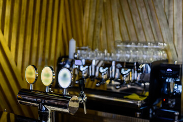 Bar counter and raw of taps for pouring beer in bar interior