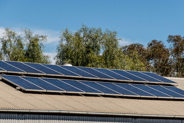 Solar panels on the roof of industrial building warehouse. Renewable solar energy.