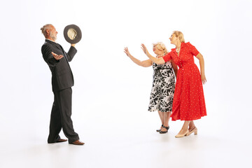 Handsome senior man and two charming women in vintage retro style outfits isolated on white...