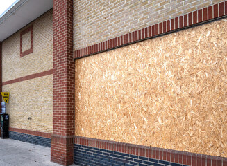 Boarded up windows of a supermarket that has recently  closed down.