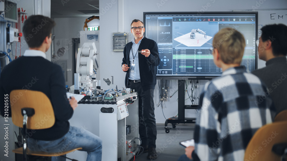 Poster teacher holding microchip for futuristic equipment during the lesson while robotic arm moving nearby