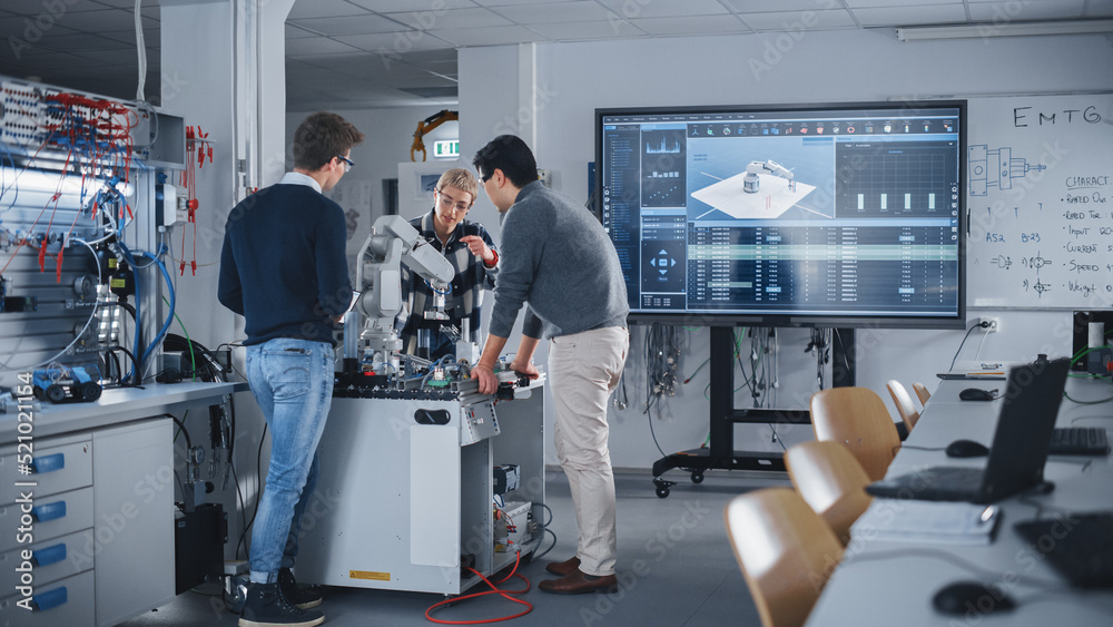 Aufkleber Diverse Team of Industrial Robotics Engineering Students Standing Around Table With Robot Hand. Boy Holding Tablet Computer to Manipulate and Program Robot. Equipment With Digital Technology Concept.