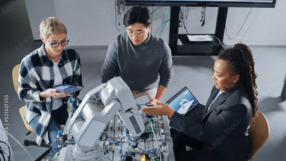 Poster Black Teacher Explaining Information to Students Gathering Around Table with Robot Limb. People Holding Devices with Apps and Discussing It at University. Education Concept. High Angle View