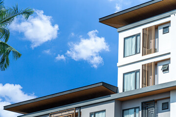 Fragment of Modern residential hotel with flat buildings exterior. Detail of New luxury house and home complex. Part of City Real estate property and condo architecture. Copy space. Blue sky