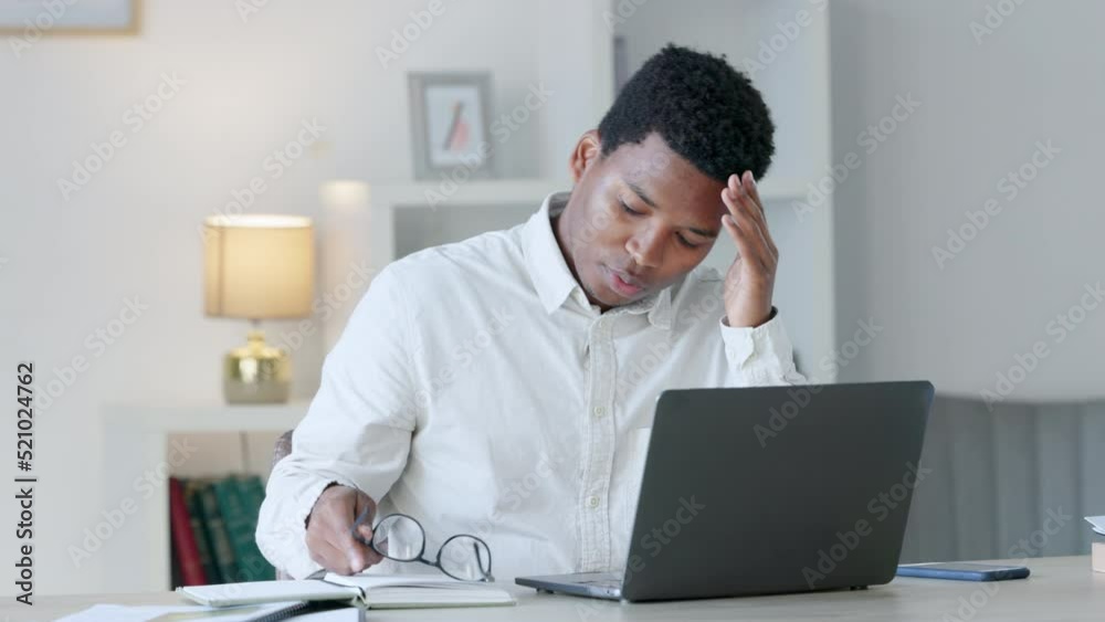 Poster stressed, tired and annoyed businessman suffering from a headache while upset and working on a lapto