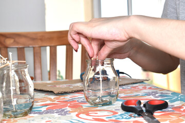 a woman creating and assembling scented candles at home