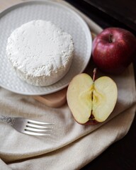 apples on the table next to a plate of cottage cheese and a fork
