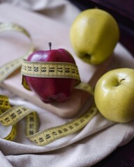 apples and cinnamon sticks on a wooden stand with a measuring tape