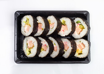 Sushi delivery box on white background. Japan menu in black transport box. Top view.