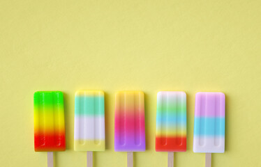 Flat lay top view colorful Ice cream stick on yellow background. Summer ice cream pastel. Minimalist food for summer holiday.