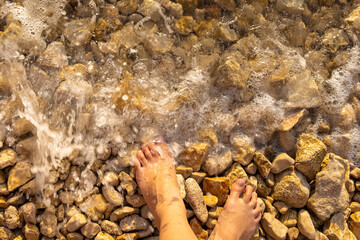 Woman feet on a pebble beach, the Adriatic Sea