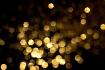 Golden blurred bokeh lights on black background. Glitter sparkle stars for celebrate. Overlay for...
