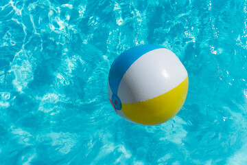 Inflatable beach ball floating on a summer swimming pool