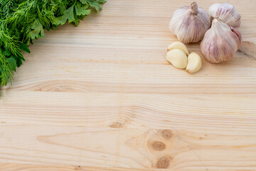 Garlic and herbs on wooden background. Top view, copy space.