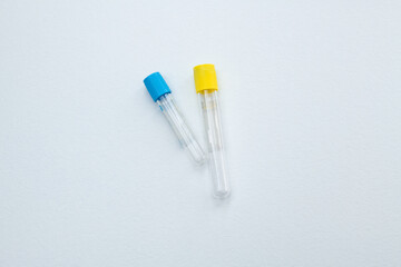 Two vacuum tubes for collection and blood samples with sodium citrate in blue gloves for laboratory. On white background