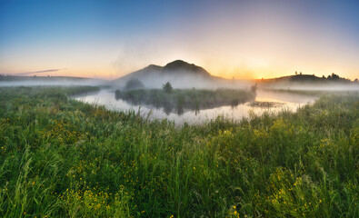 Beautiful spring sunrise over river banks. Morning fog