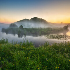 Beautiful spring sunrise over river banks. Morning fog