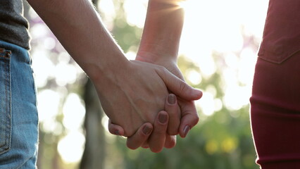 Hands held together with sunlight flare in the background