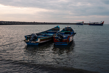 Fishing boats docked in the harbor during the sunset and blue hour