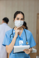 Female doctor stands at hospital. Healthcare worker. woman pharmacist with and stethoscope smiling satisfied with her job in hospital. black health professional wearing stethoscope for support Patient