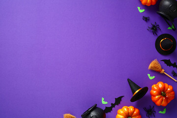Happy Halloween holiday concept. Flat lay composition with Halloween decorations, pumpkins, bats, spiders, witch hats and brooms on purple background. Top view, overhead. Halloween greeting card