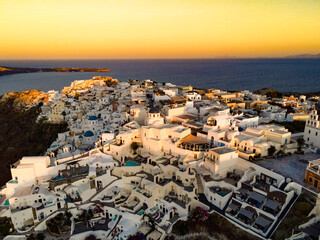 top panoramic shot drone of village of thira and oia in santorini island, greece. with coastline and focus on the cliff