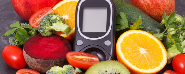 Glucometer for checking sugar level with fruits and vegetables containing vitamins, healthy eating...