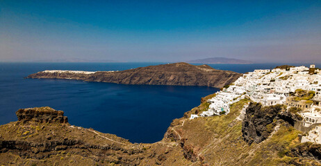 top panoramic shot drone of village of thira and oia in santorini island, greece. with coastline...