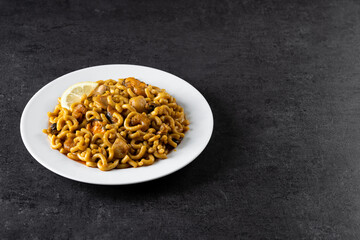 Traditional Spanish fideua. Noodle paella on black background. Copy space