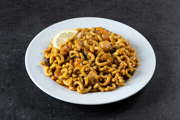 Traditional Spanish fideua. Noodle paella on black background