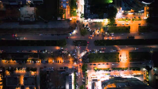 aerial drone shot at dusk twilight in gurgaon delhi looking straight down at busy intersection with skyscrapers buildings and markets showing the elegance and beauty of Indian cities