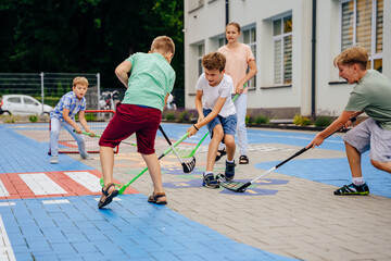 Children playing street hockey on a city holiday