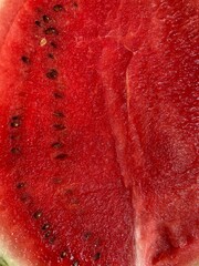a sliced watermelon with red fruit flesh and seeds