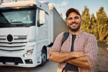 Confident truck driver with his vehicle in background on parking lot.