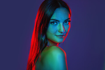 Headshot happy tender redhead girl freckles smiling in colorful neon light