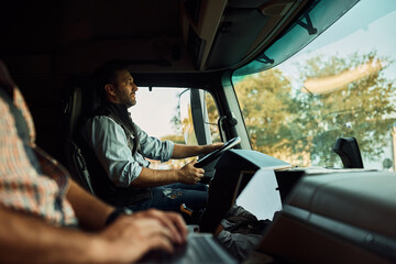 Professional driver and his colleague driving truck.