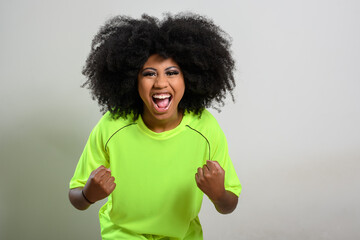 woman fan screams cheering for her team, celebrating, vibrant green uniform, young woman, gray...