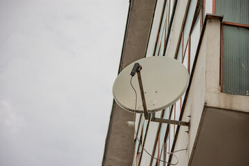 Dish antenna installed at the bottom of a balcony of an old apartment building