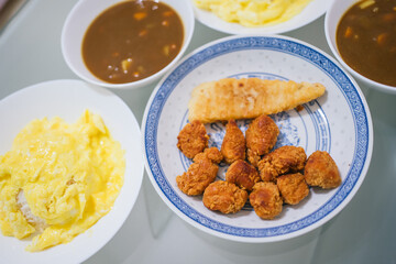 Home cook fried pop corn chicken, fish filley, omellete rice and Japanese curry