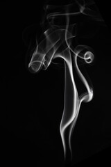 A single white smoke burn from incense, shot in studio with dark black background, for design and religion concept