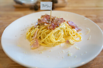 Spaghetti Carbonara with bacon and parmesan on wooden table. Italian food.