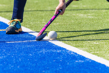 Hockey Player Obscured Short Corner Ball Hand Stick Leg Only On Astro Green Blue White Line Turf.