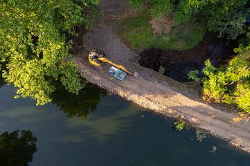 Construction machinery on a dirt road along river