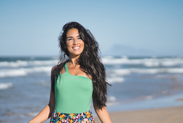 Young Muslim female model smiling while enjoying a day at the beach. Vacation concept.