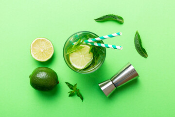 Caipirinha, Mojito cocktail, vodka or soda drink with lime, mint and straw on table background. Refreshing beverage with mint and lime in glass top view flat lay
