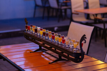 Glass stacks are filled with different drinks as an advertisement in a drinking establishment, a bar on the street