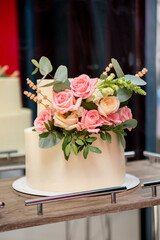 wedding cake decorated with rose flowers at the banquet. concept for a wedding event agency