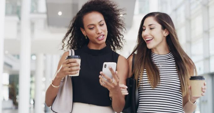Female friends and girlfriends chatting, laughing and walking together while having coffee. Smiling women talk about business news and working life. Young ladies looking at social media on a phone