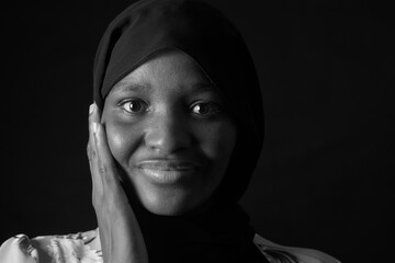 black and white dark portrait of a woman with burka and hand on face